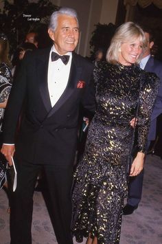 an older man in a tuxedo and woman in a sequined dress