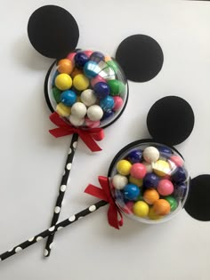 two mickey mouse lollipops on top of each other with candy in them