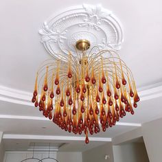 a chandelier hanging from the ceiling in a room with white walls and ceilings