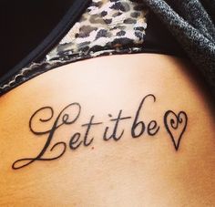 a woman's lower back tattoo with the words let it be written in cursive font