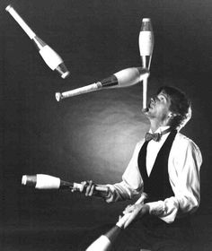 the man is juggling with his legs in the air while holding two large objects