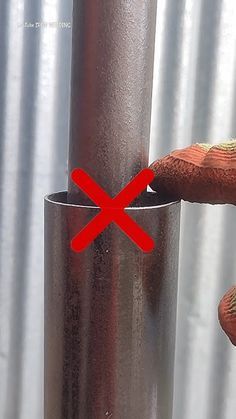 a person is holding onto a metal pole with a red cross mark on the end