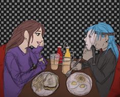 two people sitting at a table with food