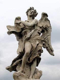 an angel statue is shown against a cloudy sky