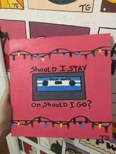 a hand holding up a pink card with an old school cassette on it that says should i stay on should i go?