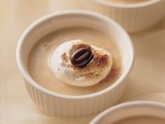 three small white bowls filled with food on top of a table next to each other