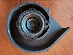 a speaker sitting on top of a wooden table