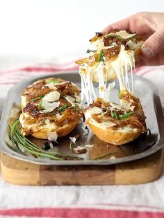 a person is taking a bite out of some appetizers on a metal tray