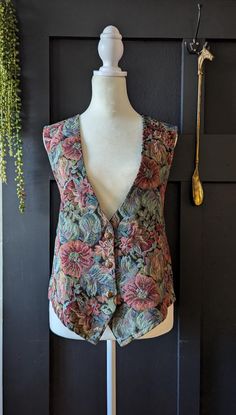 Amazing Retro 80s/90s Floral tapestry button up vest. This vest is a size large. This is in pretty good vintage condition with no rips and just minor wear. The little trendy piece can be so versatile!   Size Large.  please double check the size because we do not offer returns for clothing. Feel free to reach out with any questions about the piece! Thank you! Do you love vintage and unique items? Check out our shop page for more fantastic finds! Don't forget to give us a follow so you'll always b Cheap Retro Sleeveless Vest, Cheap 90s Vest Tops, Cottagecore Vest, Retro V-neck Spring Vest, Cheap Multicolor Vintage Vest, Spring V-neck Retro Vest, 90s Vest, Vintage Embroidered Sleeveless Vest, Vintage Floral Print Sleeveless Vest