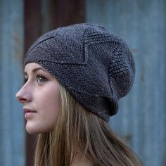 a woman with long hair wearing a gray knitted hat and looking off into the distance