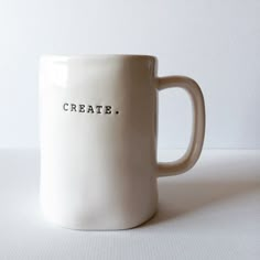 a white coffee mug with the word create written on it