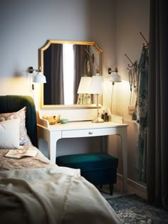 a bedroom with a bed, dressing table and mirror on it's side wall