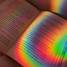 an open book with rainbow light coming from it's pages and the text on top