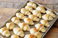 freshly baked croissants sitting on a baking tray ready to go into the oven