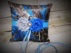 a blue and white pillow with flowers on the front is sitting on a wooden floor