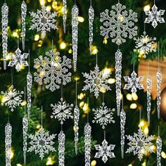 a christmas tree with ornaments hanging from it's branches and lights in the background