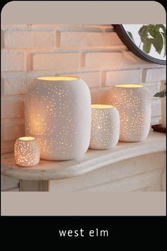 three white candles sitting on top of a table