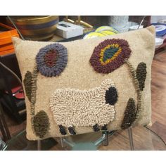 a decorative sheep pillow on a glass table