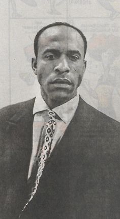 a black and white photo of a man in a suit with a neck tie on