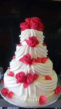 a large white cake with red flowers on it