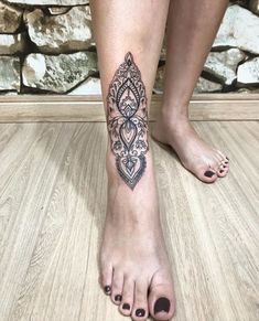 a woman's foot with a tattoo on it and an intricate design in the middle