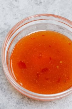 a glass bowl filled with sauce on top of a table