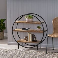 a room with a chair, table and shelves on the floor next to a potted plant