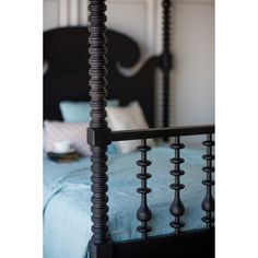 a bed with a black headboard and foot board next to a blue bedspread