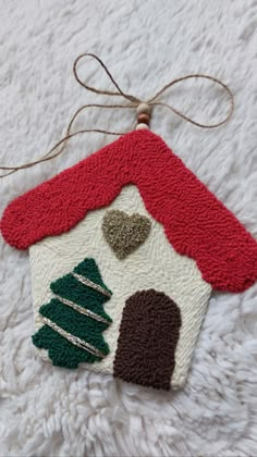 a house ornament hanging on a white blanket