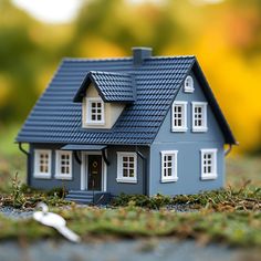 a blue house sitting on top of a green grass covered field next to a fork