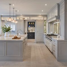 a large kitchen with marble counter tops and white cabinets