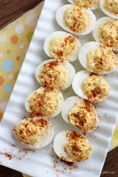 an image of deviled eggs on a white plate with cinnamon sprinkles