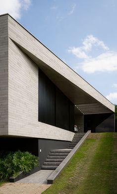 a building with stairs leading up to it and grass growing on the ground next to it