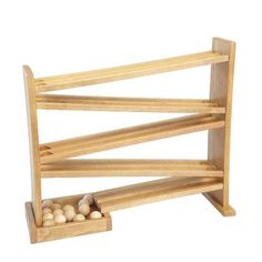 a wooden rack with eggs in it on a white background and the bottom shelf is empty