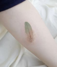 a small feather tattoo on the right arm and leg, it looks like an ostrich's tail