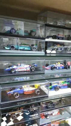 a display case filled with lots of toy cars in it's glass bins