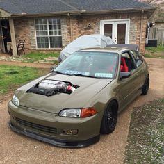 a car parked in front of a house with its hood open