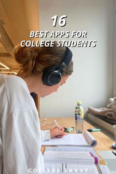 a woman sitting at a desk with headphones on writing