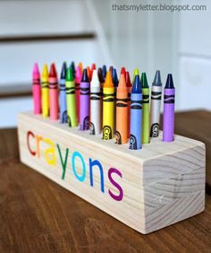 crayons are lined up on a wooden block with the word crayons