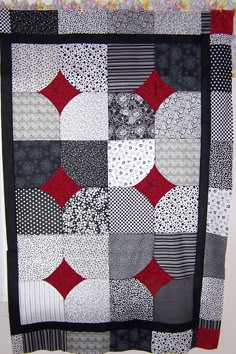 a black and white quilt with red accents