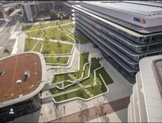 an aerial view of a building with grass on the roof and walkways in front