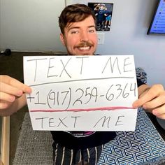 a man holding up a sign that says text me