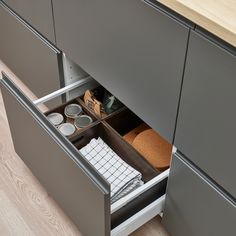 an open drawer with dishes in it