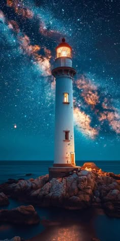 a light house sitting on top of a rocky shore under a night sky filled with stars