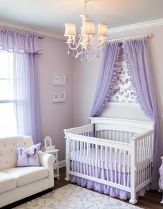 a baby's room with a white crib, purple curtains and a chandelier