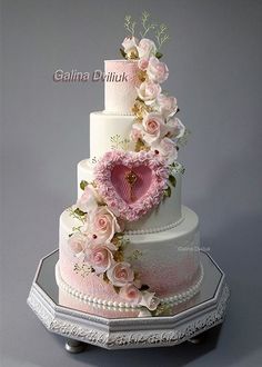 a wedding cake decorated with pink flowers and hearts