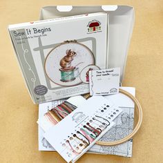 the kit includes an embroidery kit, scissors and other sewing supplies to make it look like they are working on something