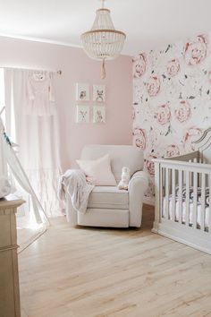 a baby's room with pink walls and floral wallpaper, a white crib and rocking chair