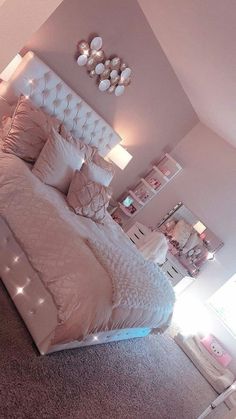 a bedroom with a large bed and lots of lights on the headboard in it