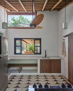 a kitchen with a ceiling fan and tiled floor